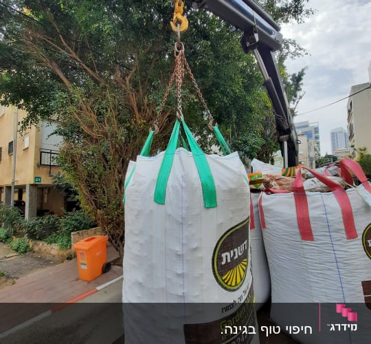 שק גדול עם חומרי גינון תלוי על מנוף